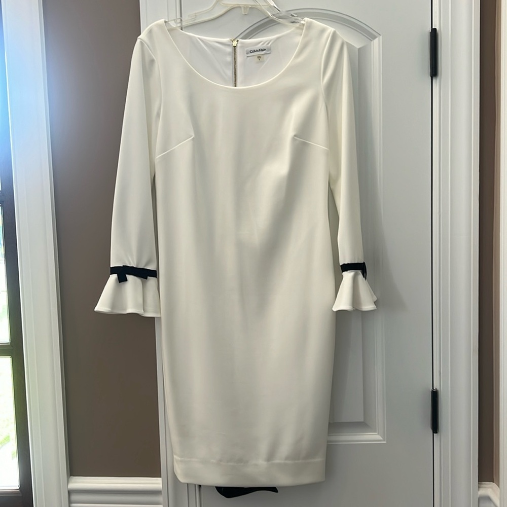 Calvin Klein white sheath dress never worn. Black bow on bell sleeves. Size 8